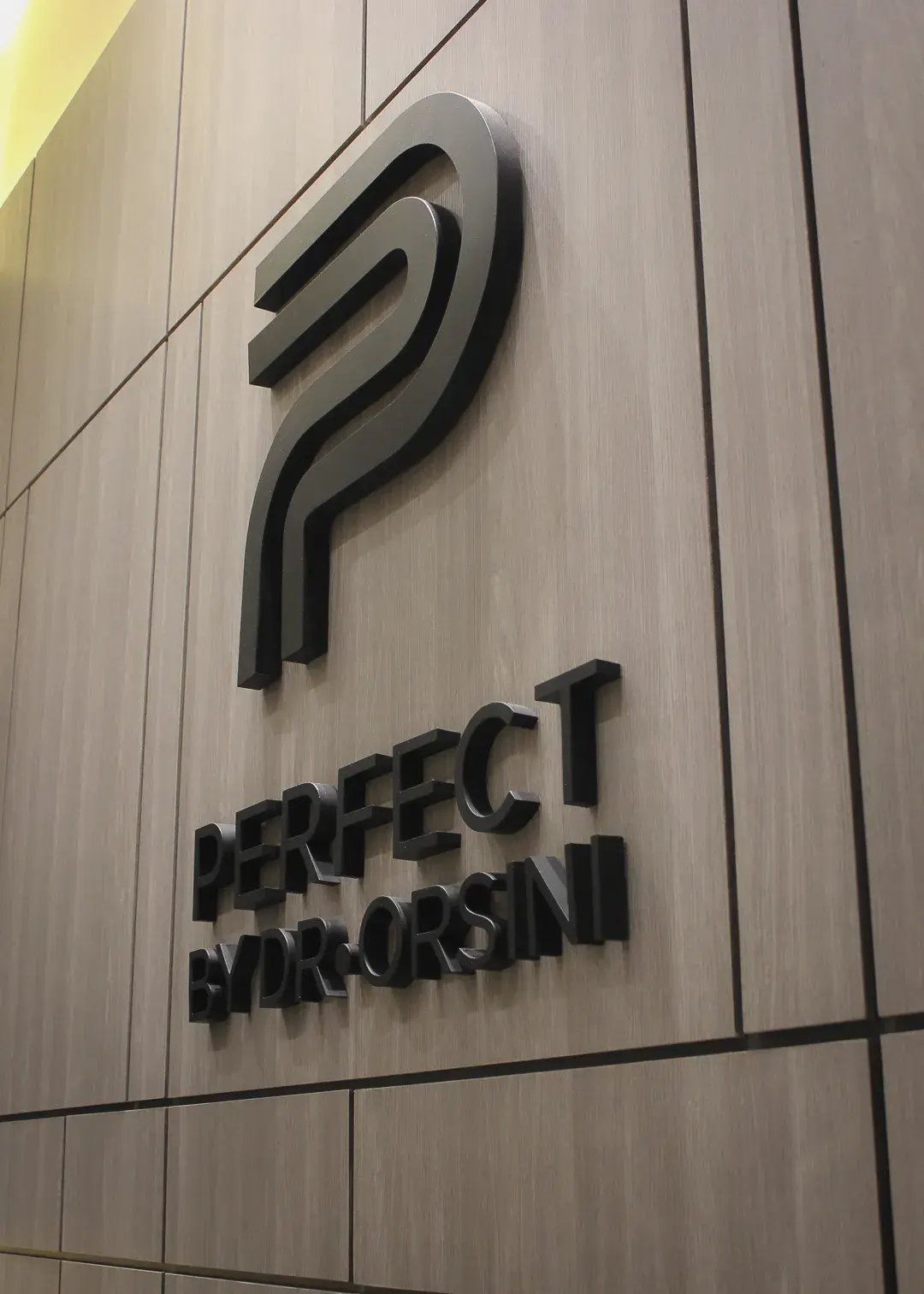 Logo de Perfect by Dr. Orsini en la recepción de la clínica