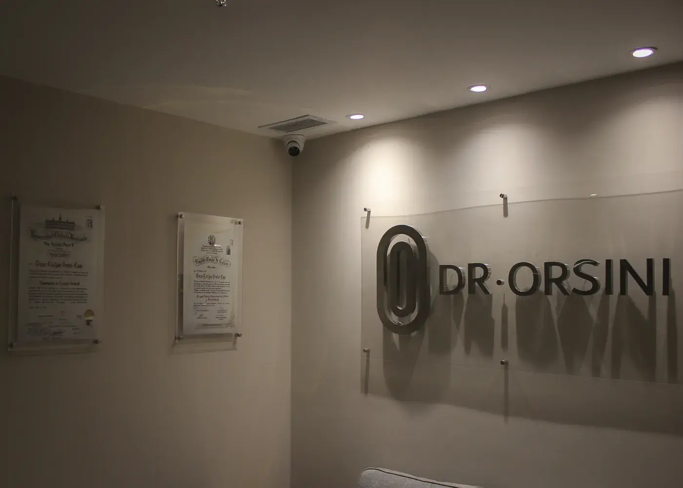 Pasillo de la clínica con los certificados del Dr. Orsini enmarcados